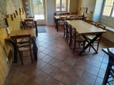 tables and chairs are lined up in a room with a brick wall