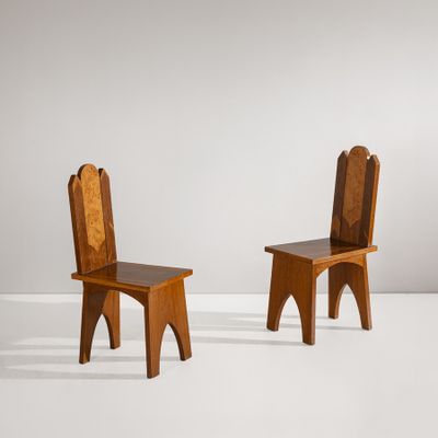 deux chaises en bois assises l'une à côté de l'autre sur une surface blanche
