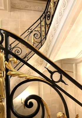 a gold statue on the stairs of a building