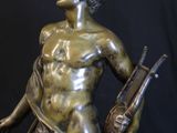 bronze statue of a man holding a rifle and a bird