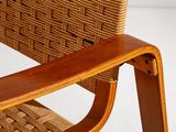 a wooden chair with a woven seat and arm rest