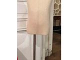 un gros plan sur un mannequin posé sur un socle dans une pièce
