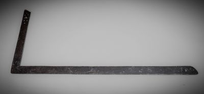 a close up of an old metal ruler on a white surface