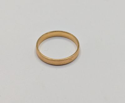 gros plan d'une bague en or sur une surface blanche