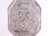 une plaque métallique sur laquelle figure une couronne