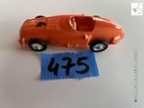 une petite voiture orange avec une étiquette bleue dessus