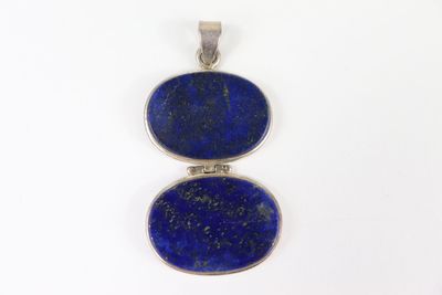 un gros plan d'un pendentif en pierre bleue sur fond blanc