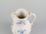 a small blue and white pitcher on a table
