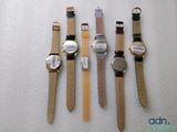 four watches are lined up in a row on a white surface