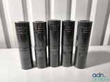 four black tubes of lipstick are lined up on a table