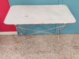 a small white table with a metal frame on it