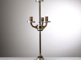 un chandelier en métal et en verre avec trois bougies, posé sur une table