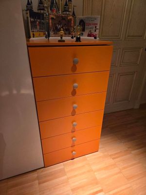 une commode orange dans un coin de la pièce