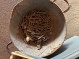 a bucket full of old keys and screws on the floor