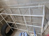 a metal shelf that has a tire on top of it