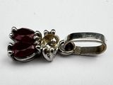 a close up of a red flower charm on a white surface
