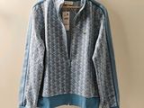 une veste bleue et blanche accrochée au mur à côté d'un cintre