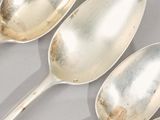 three spoons that are sitting on a table