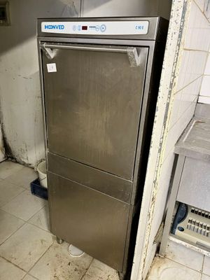une photo d'un réfrigérateur en acier inoxydable dans une cuisine sale