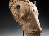 une tête de cheval antique posée sur un socle, sur fond noir