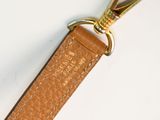 tan leather key foble with gold metal clasp on a white background
