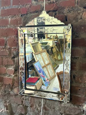 a mirror hanging on a brick wall with books on it