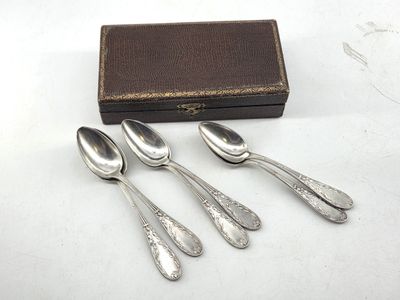 three silver spoons and a box on a white surface
