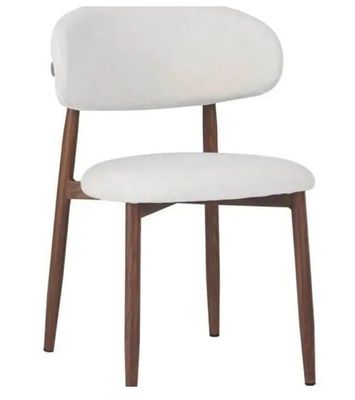 un gros plan sur une chaise blanche aux pieds en bois et à l'assise blanche