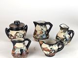 three pieces of porcelain teapots and a cup on a white surface