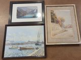 three framed paintings of boats on a table next to a wall