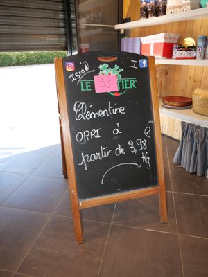 a chalk board with a sign on it in front of a store