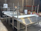 stainless steel work tables in a warehouse with shelves and shelves