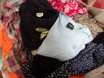 a suitcase full of clothes and clothes sitting on the floor