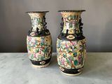 une paire de vases chinois posés sur une table, sur fond gris