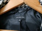 a close up of a black and white coat with a wooden hanger