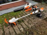 two lawn mowers sitting on the ground next to each other
