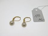 une paire de boucles d'oreilles en perles et une étiquette de prix posée sur une table