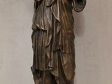 statue en bronze d'une femme tenant un oiseau dans sa main
