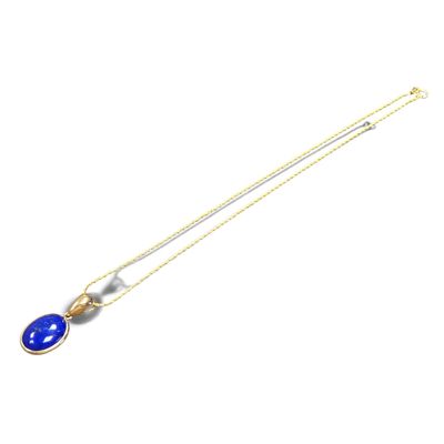a gold necklace with a blue glass pendant on it
