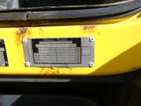 a close up of a yellow vehicle with a number plate on it