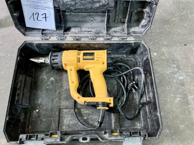 une perceuse filaire dans un coffret posé par terre