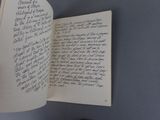 a handwritten poem in a book on a table