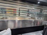 un grand comptoir en acier inoxydable dans un magasin doté d'une vitrine