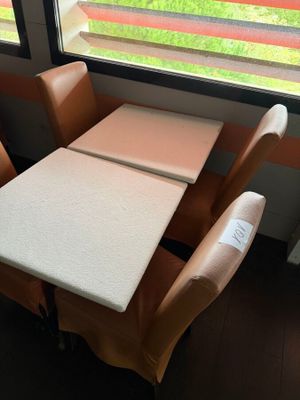 a table and chairs in front of a window with a view of a field