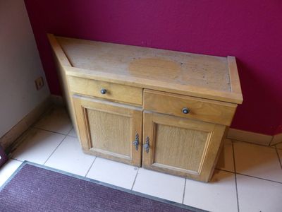 un petit meuble en bois dans un coin de la pièce
