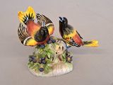 two birds that are sitting on top of a tree stump