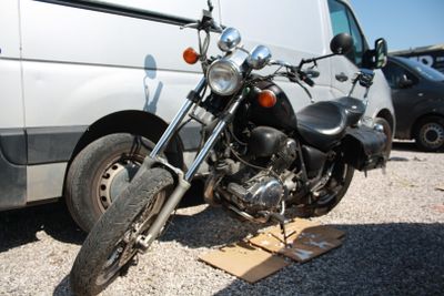 une moto garée à côté d'une camionnette sur un parking