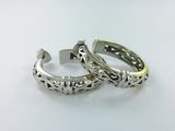 pair of silver rings with filigree designs on them on a white surface