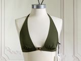 un mannequin portant un haut de bikini vert, posé sur un socle