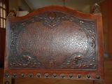 carvings on the back of a wooden bed frame in a room